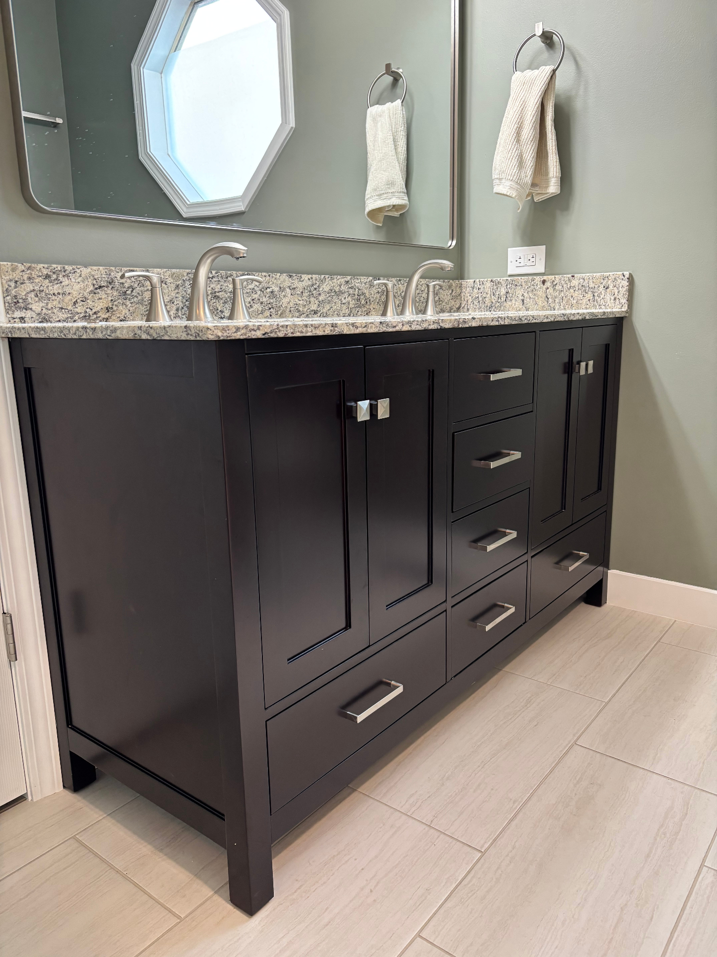 Close-up of espresso double-sink shaker vanity with granite countertop and brushed-nickel hardware