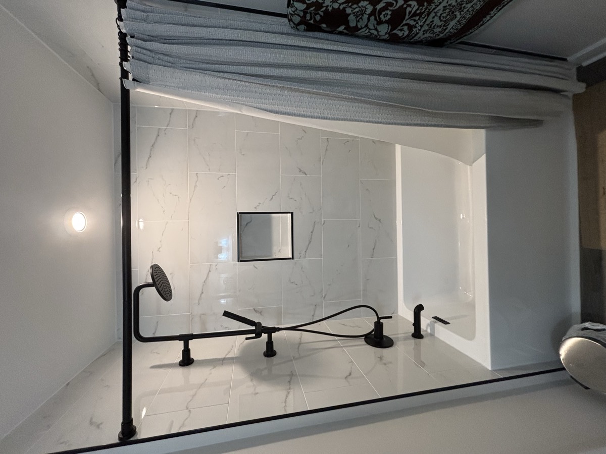 After — freestanding tub with marble accent wall